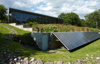 exterior-of-greenhouse-with-constructed-wetlands-and-solar-panels-in-foreground