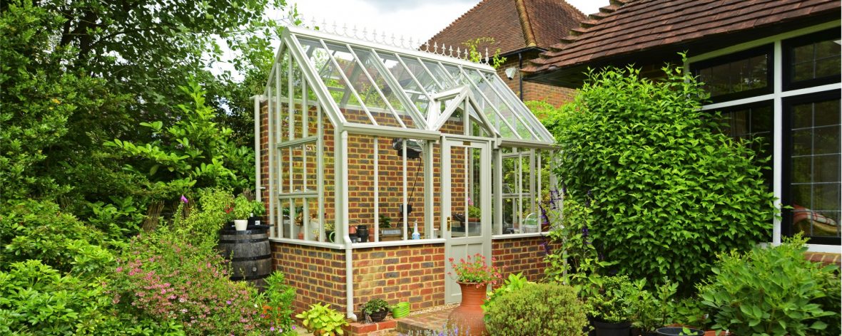 Front View of a White Hartley Botanic Bespoke Lean To Glasshouse With Brick Base.